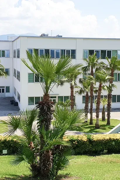 L'edificio del Centro Neapolisanit a Ottaviano, tra le palme del parco